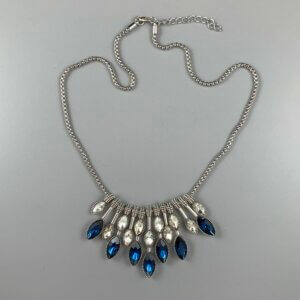 Short silver necklace with silver and blue crystal ovals hanging from a silver snake chain