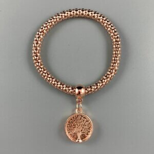 Vive Rose gold coloured tree of life charm hangs from a rose gold coloured elasticated bracelet