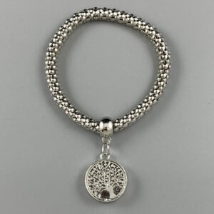 Vive silver coloured tree of life charm hangs from a silver coloured elasticated bracelet